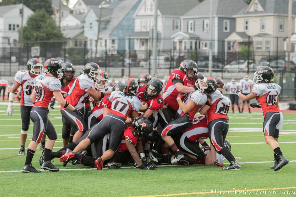 Hillary Crook #75 knocks back a Chicago Force defender while quarterback Allison Cahill pushes forward for a first down. ©Mitzi Velez Lorenzana